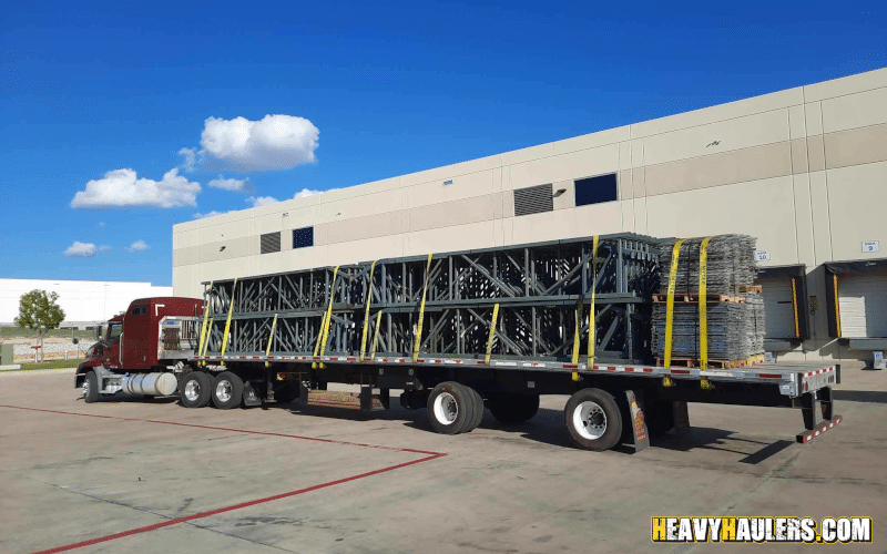 Transporting pallet racks on a flatbed trailer.