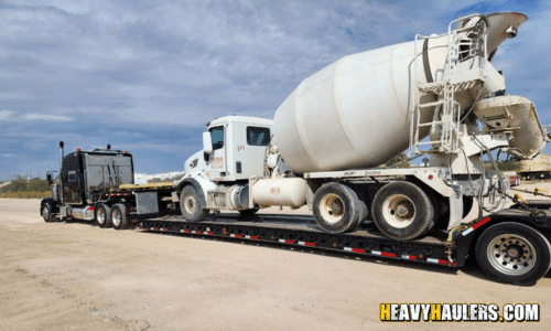 Transporting a cement truck on a lowboy trailer.