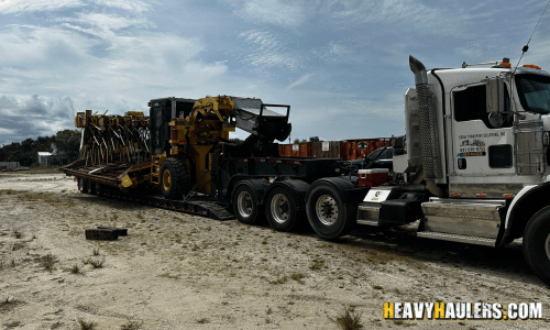 Shipping construction equipment on a lowboy trailer.
