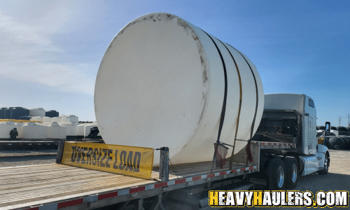 5000 Gallon HDPE Vertical Tank loaded on a step deck trailer for transport