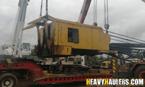 Double wrecker crane being loaded by crane for transport