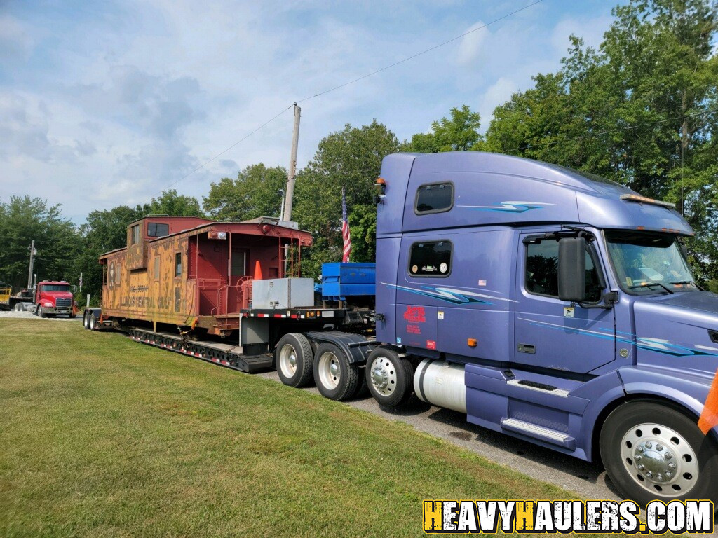 Semi truck hauling a caboose.