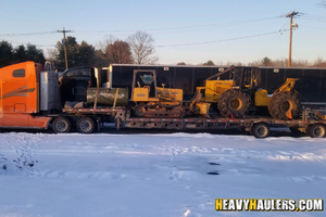 Two skidders loaded on a trailer.