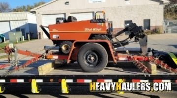 Loading and securing a Ditch Witch vibratory plow on a trailer.