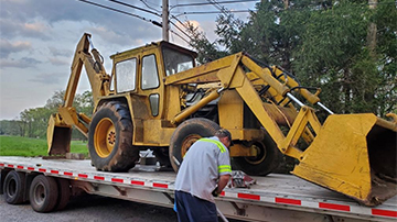 Backhoe 5550 strapped down for transport.