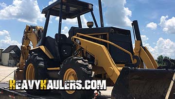 Caterpillar backhoe on a step deck trailer.