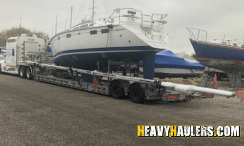 Sailboat transport on a lowboy trailer.
