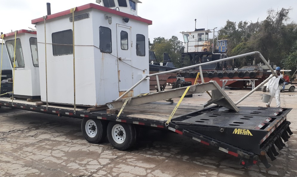 Shipping a tugboat in pieces on trailers.