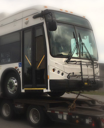 Hot shot trailer moving a bus