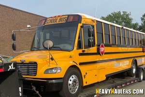 2021 Thomas Built Bus Saf-T-Liner C2 Jouley loaded on an RGN trailer.