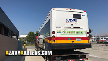 Loading an electric transit bus on a trailer.