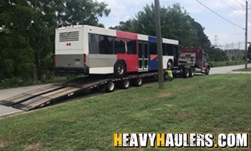 Bus transported on a step deck trailer.