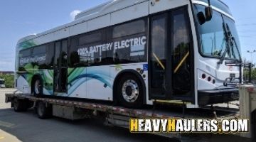 Transporting an electric bus on a flatbed trailer.