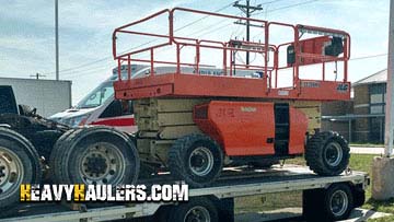 Loading a 2014 JLG construction lift on a trailer.
