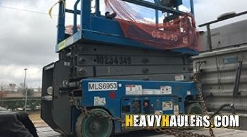 Shipping a Genie scissor lift on a flatbed trailer.