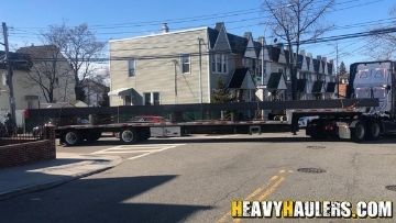 Steel beams transported on a step deck trailer.