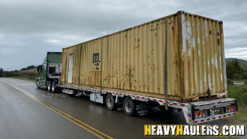 Container on the back of a step deck trailer