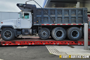 A 1999 Mack tri axle dump trump hauled on an RGN trailer.