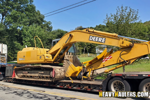 John Deere 200C LC excavator loaded on a trailer.