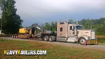 Excavator transported by semi truck.