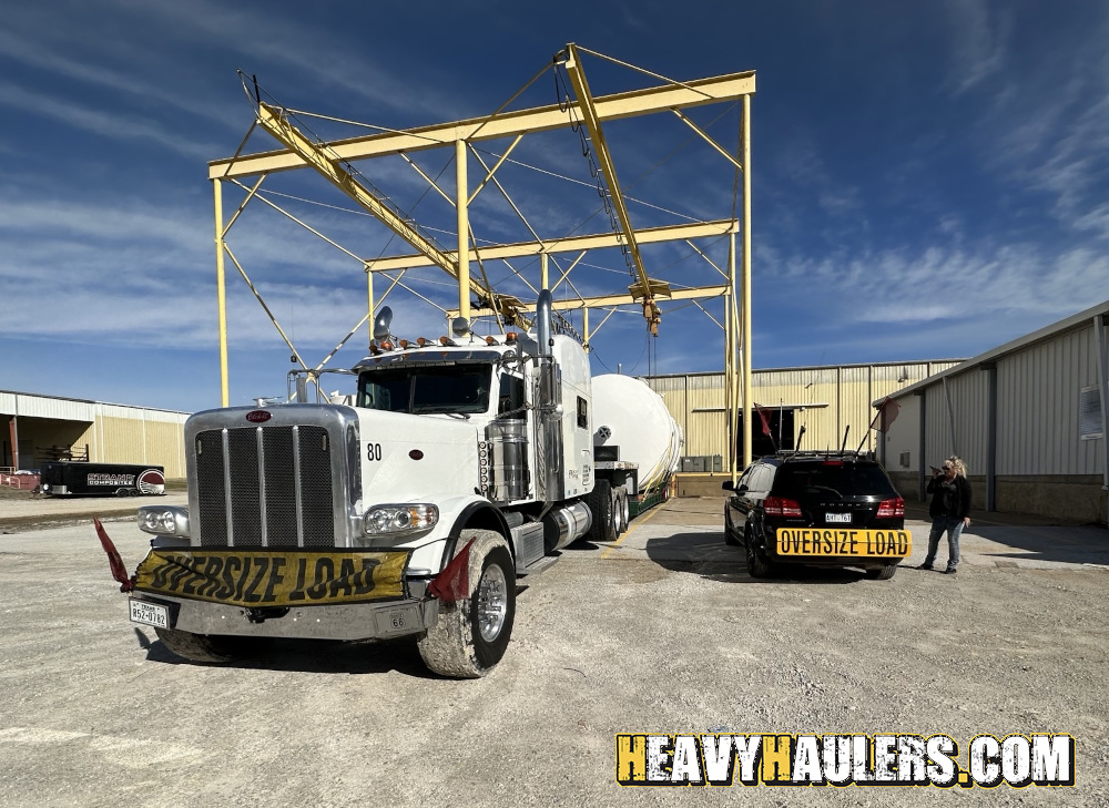 Shipping an oversize fiberglass tank on a lowboy trailer.