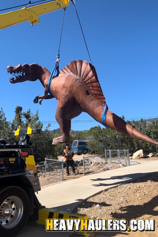 Spinosaurus hoisted up by a rotary truck.