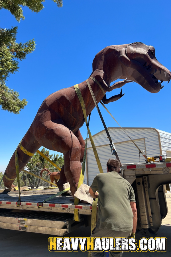 Strapping a steel t-rex to a trailer.