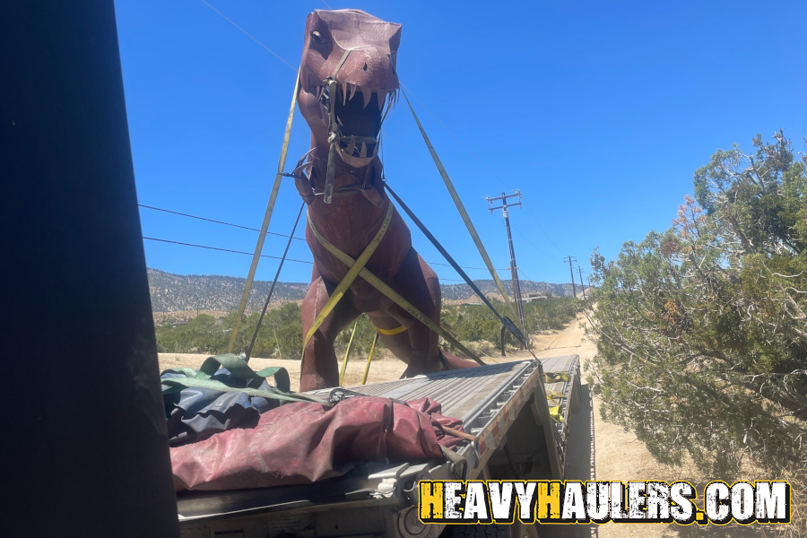 Transporting an oversize steel t-rex on a trailer.