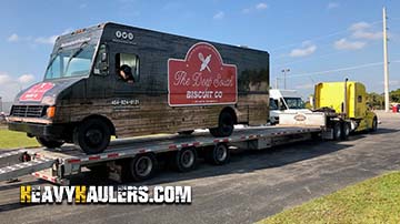 Chevy food tuck on a 6 axle flat bed trailer.