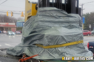 Komatsu Reach forklift transported on a flatbed trailer.