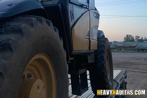 CAT 460B telehandler loaded on a trailer for transport.