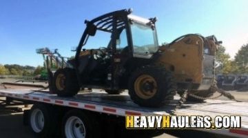 Transporting a forklift on a flatbed trailer.