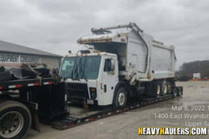 Loading a 2010 Mac LE with Hail Front Load Body (Inoperable) on a trailer.