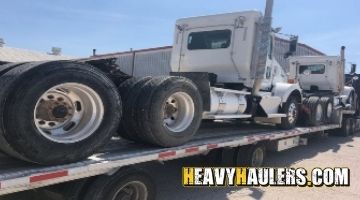 Kenworth daycabs loaded on a trailer.