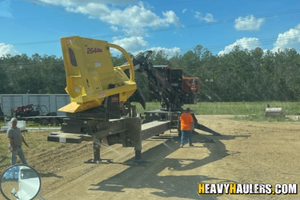 Loading a 2022 BARKO 595B LOG LOADER on a trailer.