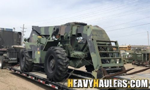 Loading a custom telehandler military truck on an RGN trailer.