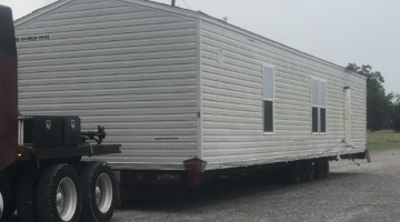 Transporting a mobile home on a trailer.