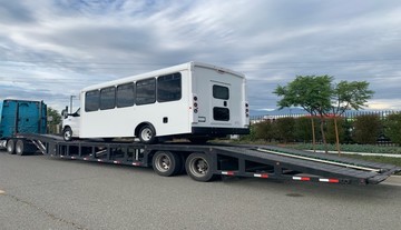 Loading a shuttle bus on a trailer.