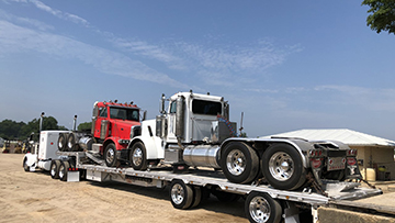 Peterbilt daycab trucks hauled on a stepdeck trailer