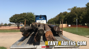 wood utility poles transport on a flatbed