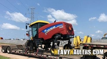 Loading a New Holland swather speedrower on an RGN trailer.