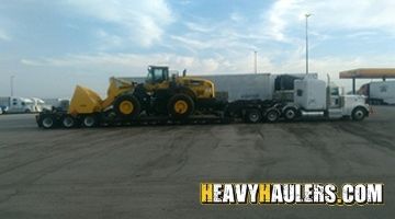 Hauling a Komatsu wheel loader on a flatbed trailer.