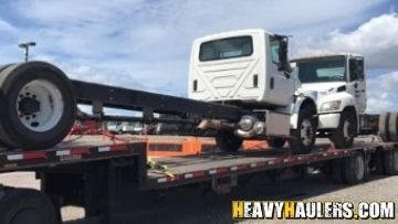 Transporting two International daycabs on a trailer.