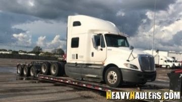 Loading an International Prostar sleeper truckon a trailer.
