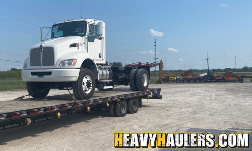 white day cab semi truck transport on a tariler