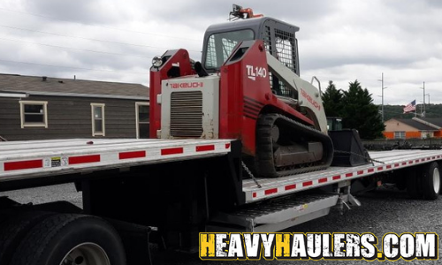 Shipping a skid steer on a step deck trailer.