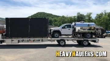 Hauling a tank truck on a step deck trailer.