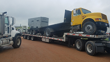 Transporting a heavy duty truck on a drop deck trailer.