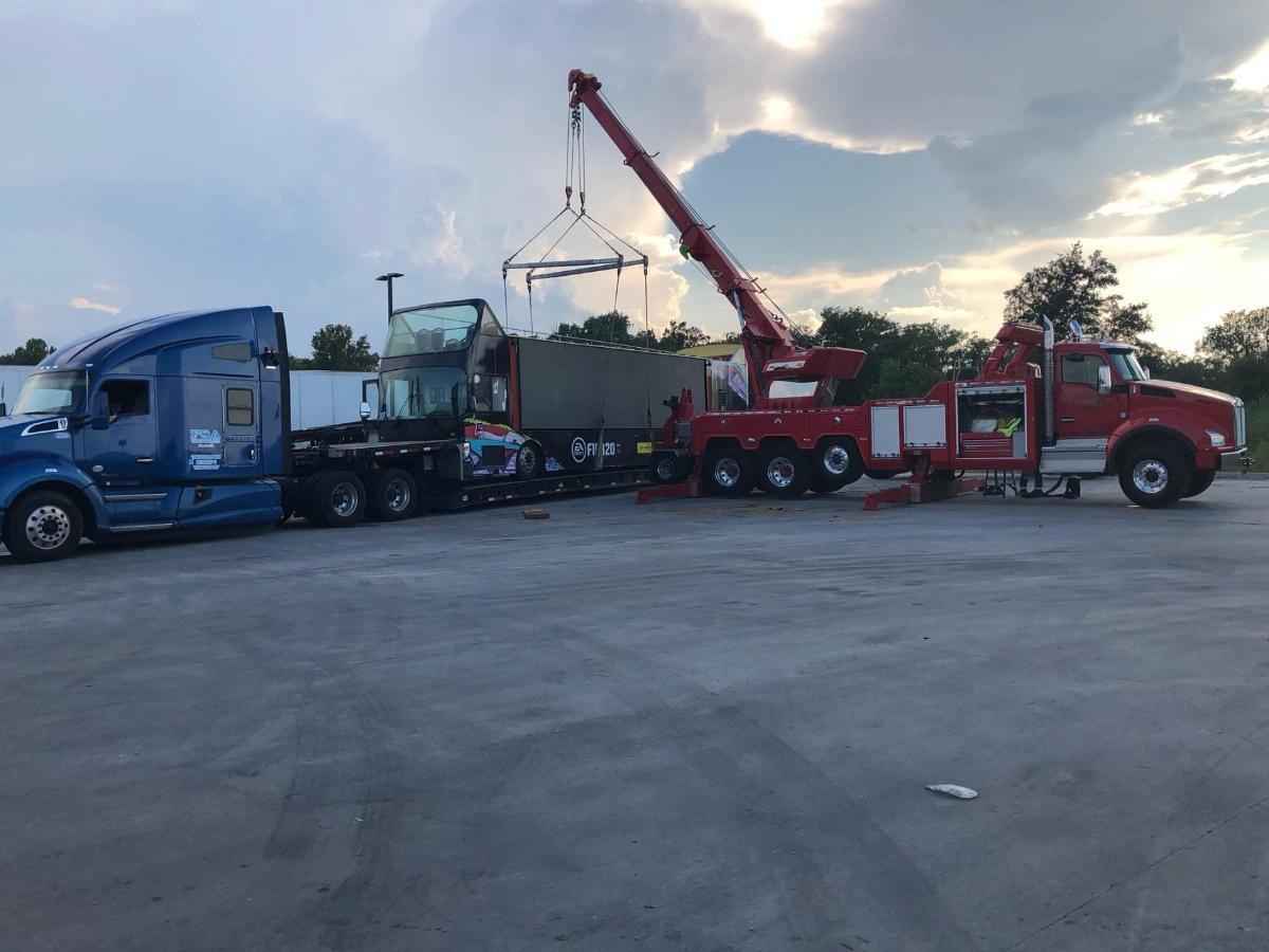 Using a crane to load a double decker bus on a trailer.