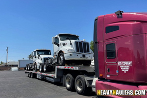 (2) 2015 Volvo Day Cabs loaded on a step deck trailer.
